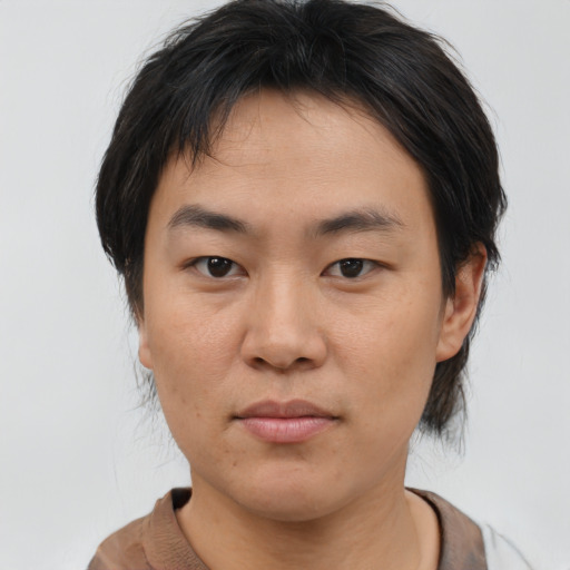 Joyful asian young-adult male with medium  brown hair and brown eyes