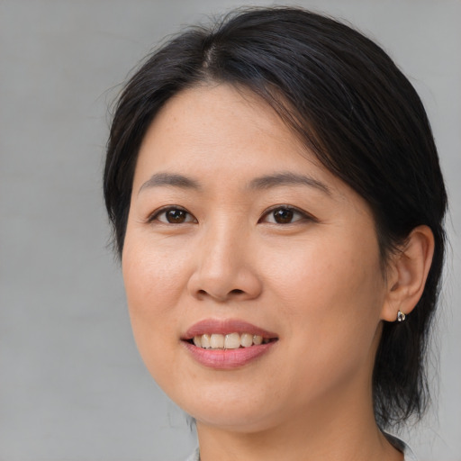 Joyful asian young-adult female with medium  brown hair and brown eyes