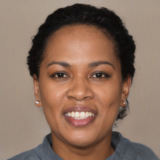 Joyful black young-adult female with short  black hair and brown eyes