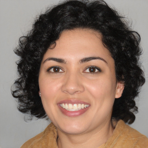 Joyful latino young-adult female with medium  brown hair and brown eyes