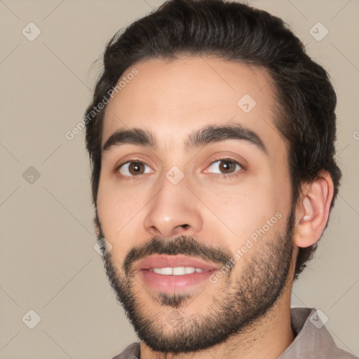 Joyful white young-adult male with short  black hair and brown eyes