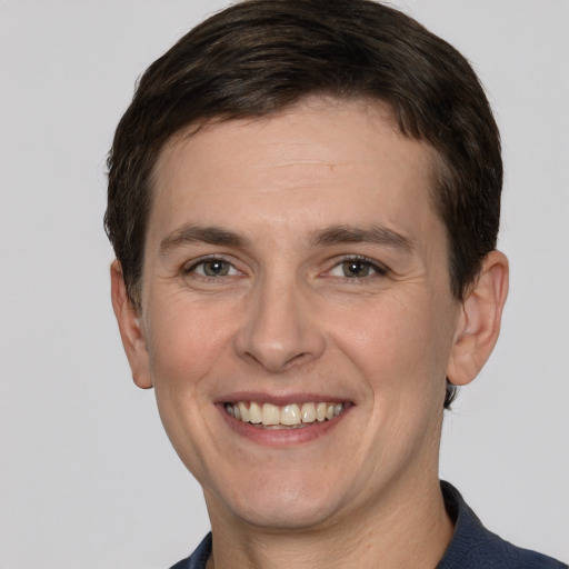 Joyful white adult male with short  brown hair and grey eyes