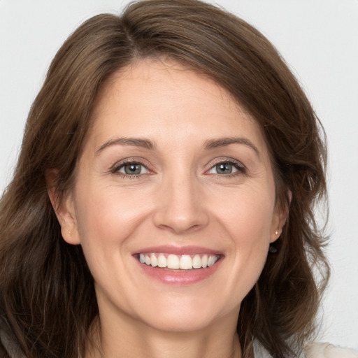 Joyful white young-adult female with long  brown hair and grey eyes