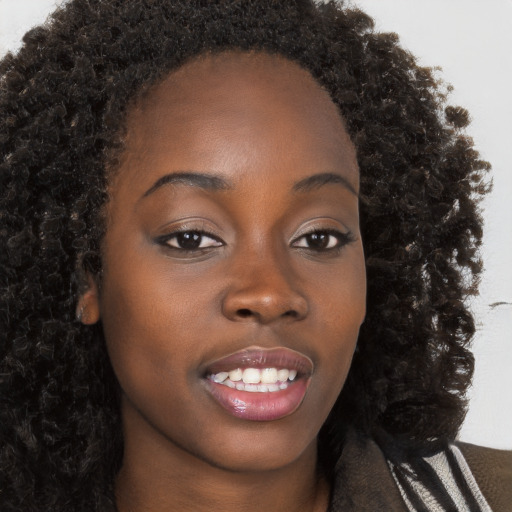 Joyful black young-adult female with long  brown hair and brown eyes