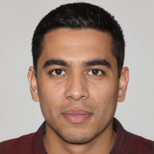 Joyful latino young-adult male with short  black hair and brown eyes