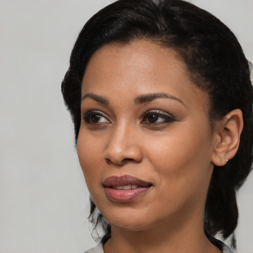Joyful black young-adult female with short  black hair and brown eyes