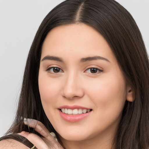 Joyful white young-adult female with long  brown hair and brown eyes