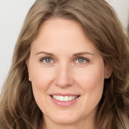 Joyful white adult female with long  brown hair and grey eyes