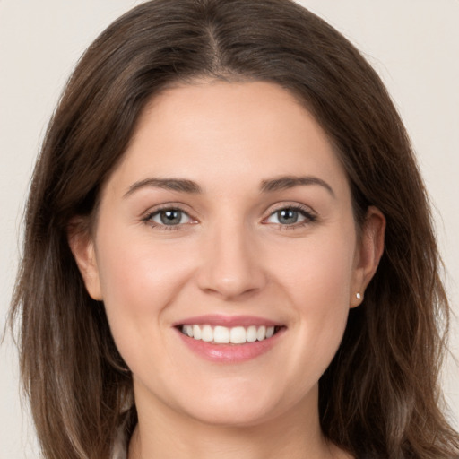 Joyful white young-adult female with long  brown hair and grey eyes