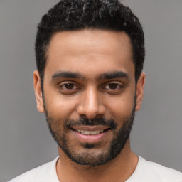 Joyful latino young-adult male with short  black hair and brown eyes