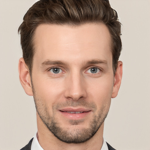 Joyful white young-adult male with short  brown hair and grey eyes