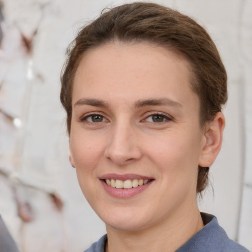 Joyful white young-adult female with short  brown hair and grey eyes