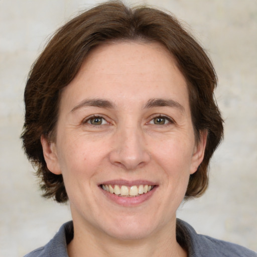 Joyful white adult female with medium  brown hair and grey eyes