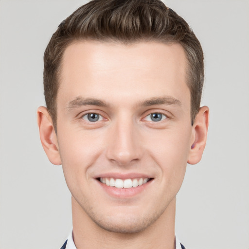 Joyful white young-adult male with short  brown hair and grey eyes