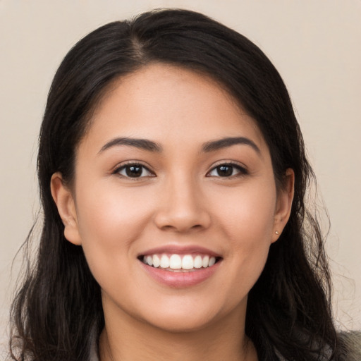 Joyful latino young-adult female with long  black hair and brown eyes