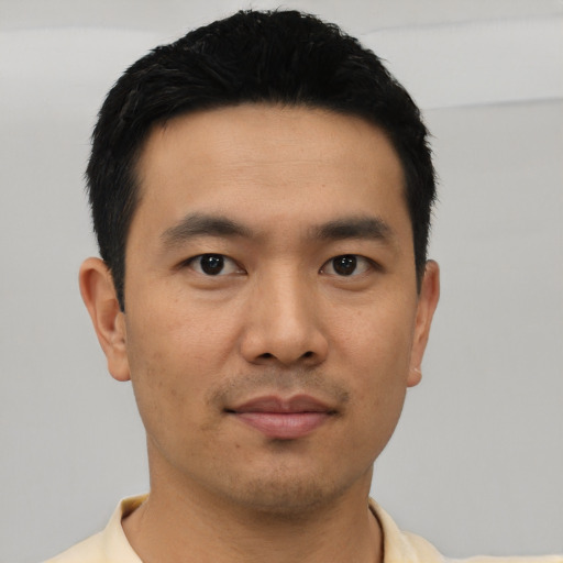 Joyful asian young-adult male with short  black hair and brown eyes