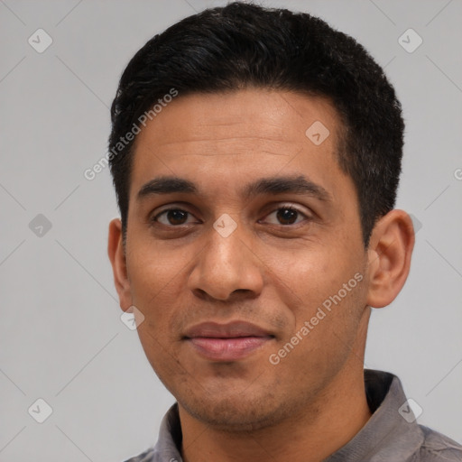 Joyful latino young-adult male with short  black hair and brown eyes