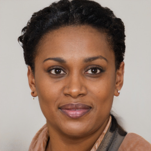 Joyful black young-adult female with short  brown hair and brown eyes