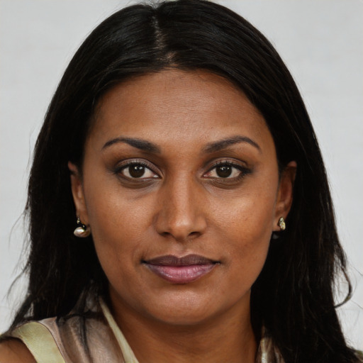 Joyful black young-adult female with long  brown hair and brown eyes