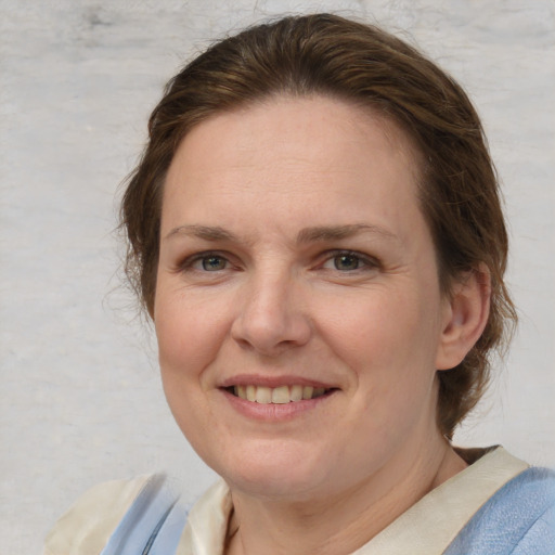 Joyful white adult female with medium  brown hair and blue eyes