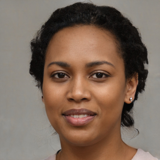 Joyful black young-adult female with medium  black hair and brown eyes