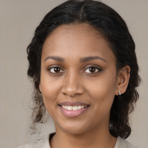 Joyful black young-adult female with medium  brown hair and brown eyes