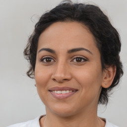 Joyful latino young-adult female with medium  brown hair and brown eyes