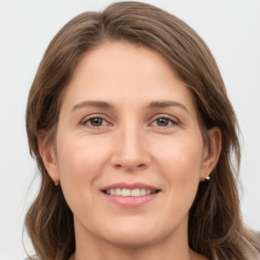 Joyful white young-adult female with long  brown hair and grey eyes