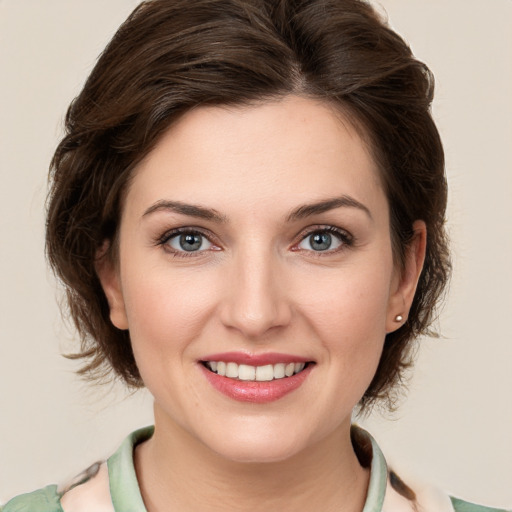 Joyful white young-adult female with medium  brown hair and green eyes