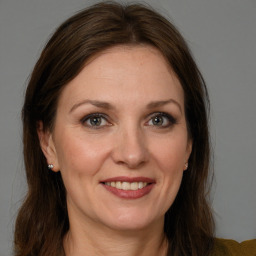 Joyful white adult female with long  brown hair and brown eyes