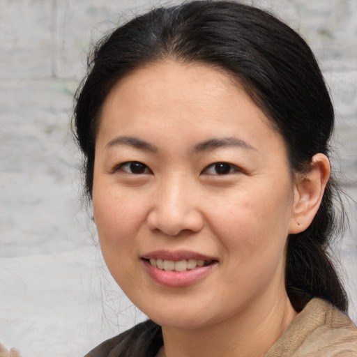 Joyful asian young-adult female with medium  brown hair and brown eyes