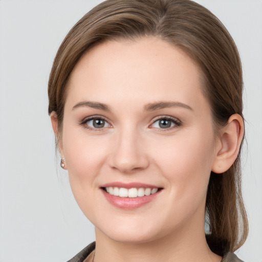 Joyful white young-adult female with long  brown hair and grey eyes