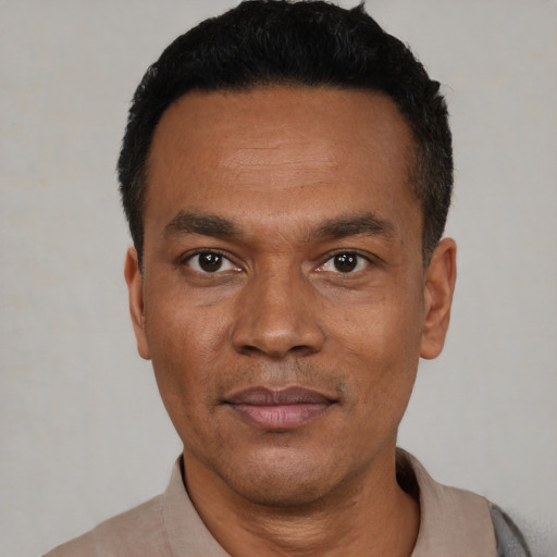 Joyful black young-adult male with short  black hair and brown eyes