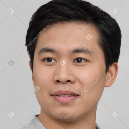 Joyful asian young-adult male with short  black hair and brown eyes