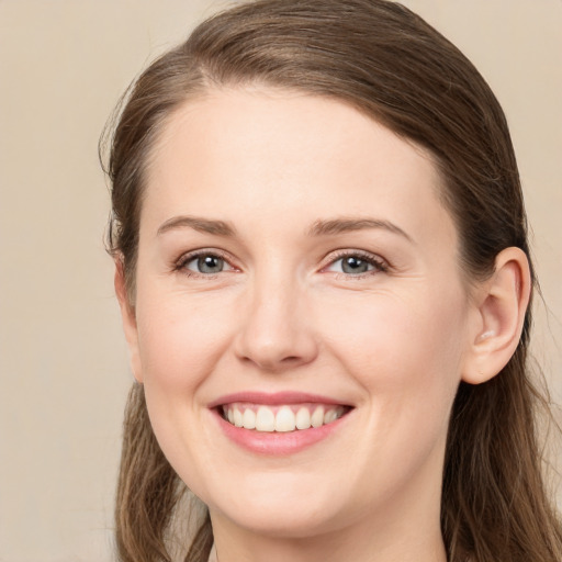 Joyful white young-adult female with long  brown hair and grey eyes