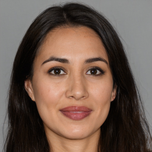 Joyful latino young-adult female with long  brown hair and brown eyes