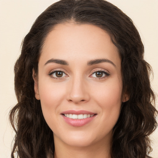 Joyful white young-adult female with long  brown hair and brown eyes