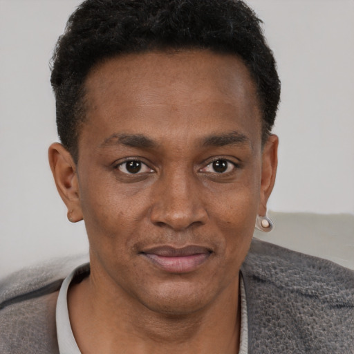 Joyful black young-adult male with short  brown hair and brown eyes