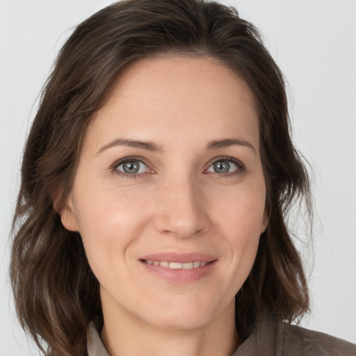 Joyful white adult female with medium  brown hair and brown eyes