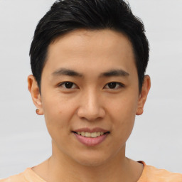 Joyful asian young-adult male with short  black hair and brown eyes