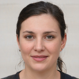 Joyful white young-adult female with medium  brown hair and grey eyes