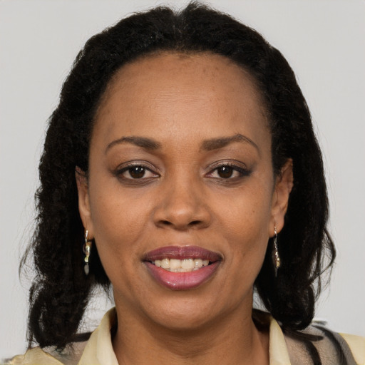 Joyful black adult female with long  brown hair and brown eyes