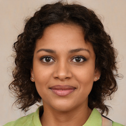 Joyful black young-adult female with medium  brown hair and brown eyes