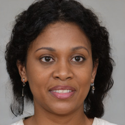 Joyful black adult female with medium  brown hair and brown eyes