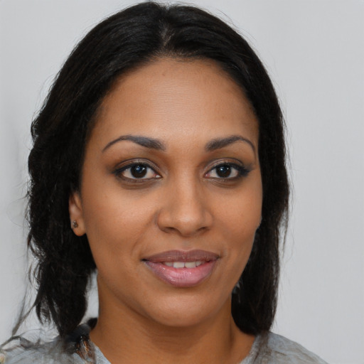 Joyful black young-adult female with medium  brown hair and brown eyes