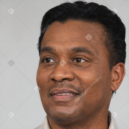 Joyful black adult male with short  black hair and brown eyes