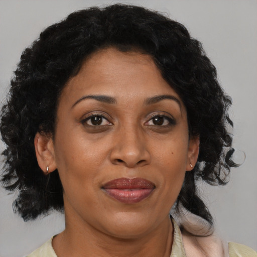 Joyful black adult female with medium  brown hair and brown eyes