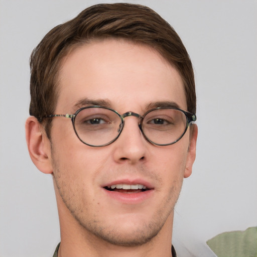 Joyful white young-adult male with short  brown hair and blue eyes