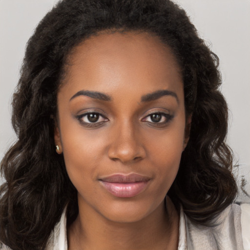 Joyful black young-adult female with long  brown hair and brown eyes