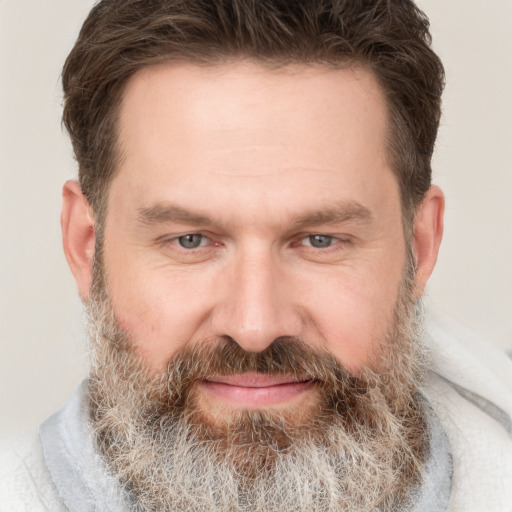 Joyful white adult male with short  brown hair and grey eyes